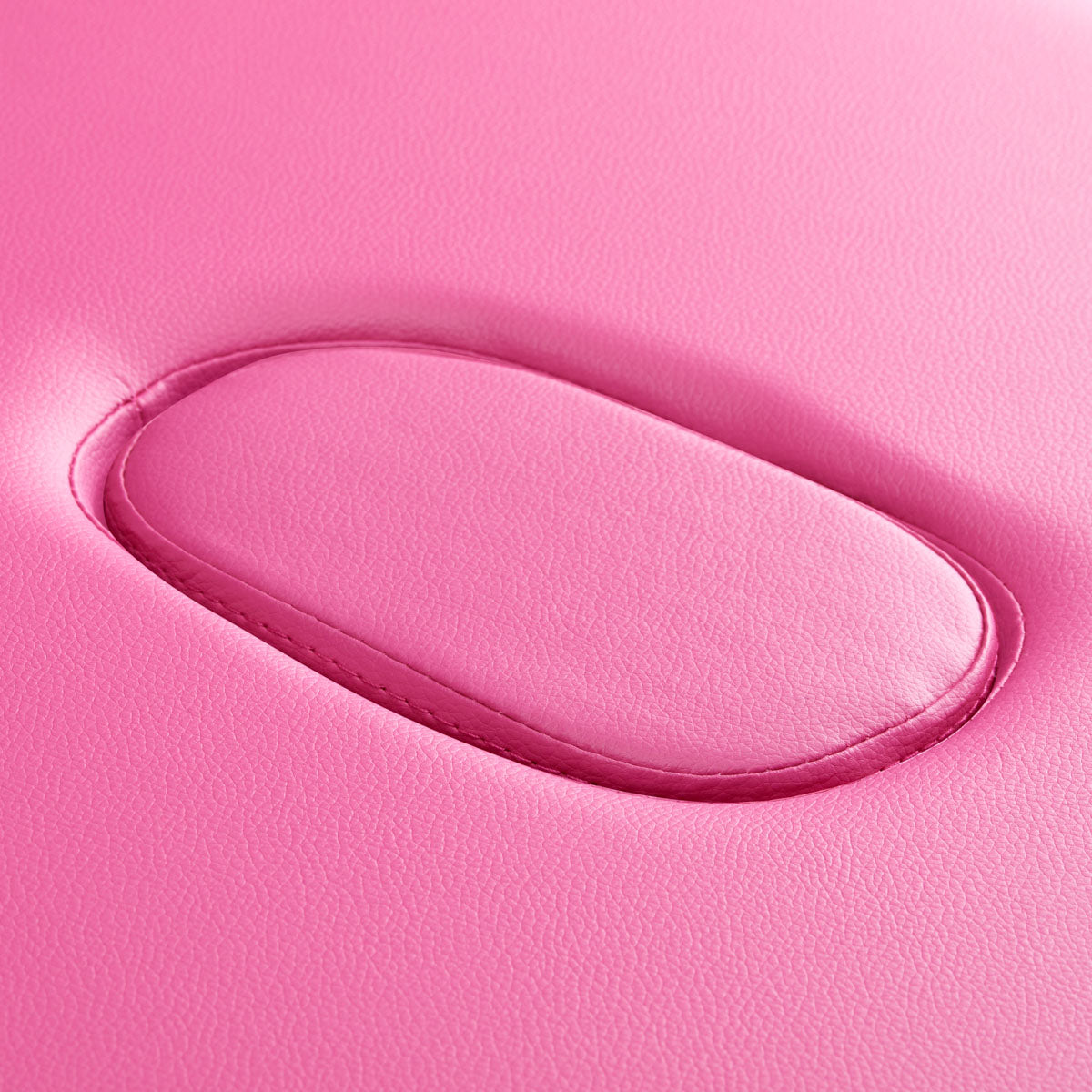 Roze lederen bekleding met ovale uitsparing voor hoofdsteun op massagetafel