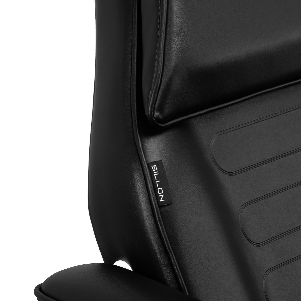 Close-up of black leather hydraulic treatment chair with Sillon tag.