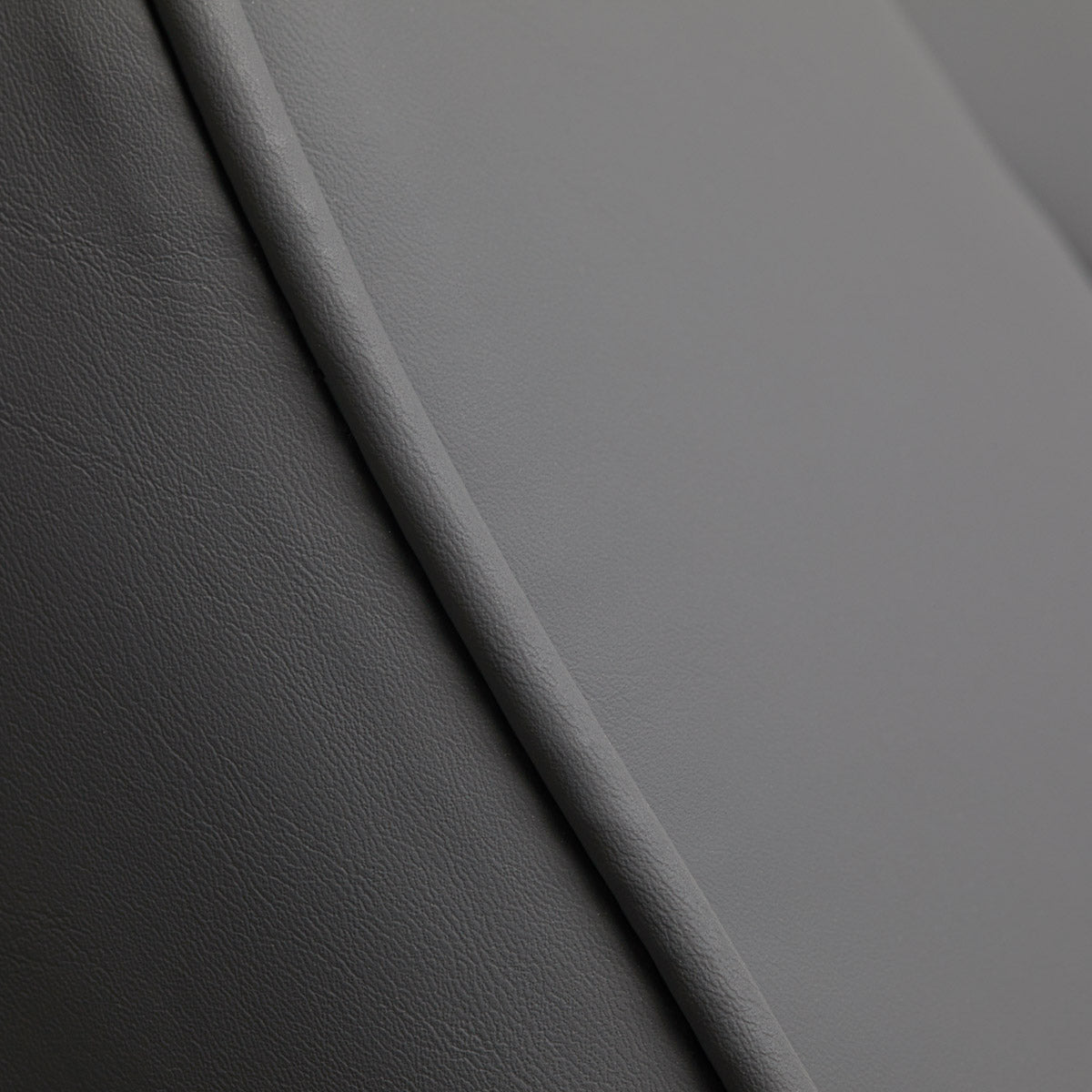 Grey leather upholstery close-up on Sillon Lux 273B electric treatment chair.